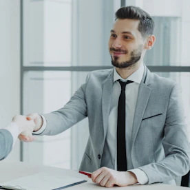 Professionista sorridente che stringe la mano a un cliente